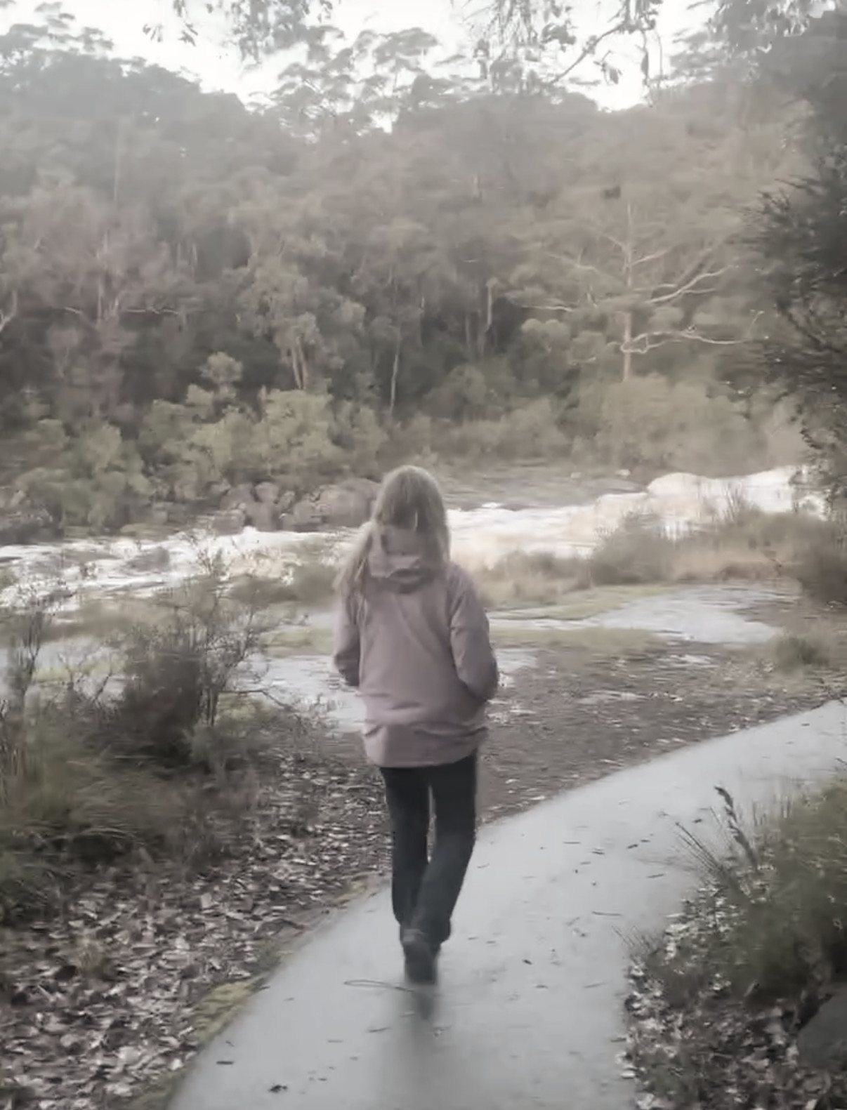 Chiara walking along a riverside path